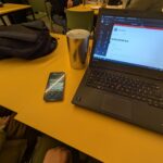 Laptop e Telefono appoggiati ad un tavolo in bar