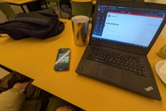 Laptop e Telefono appoggiati ad un tavolo in bar