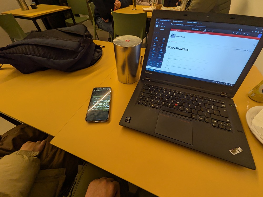 Laptop e Telefono appoggiati ad un tavolo in bar